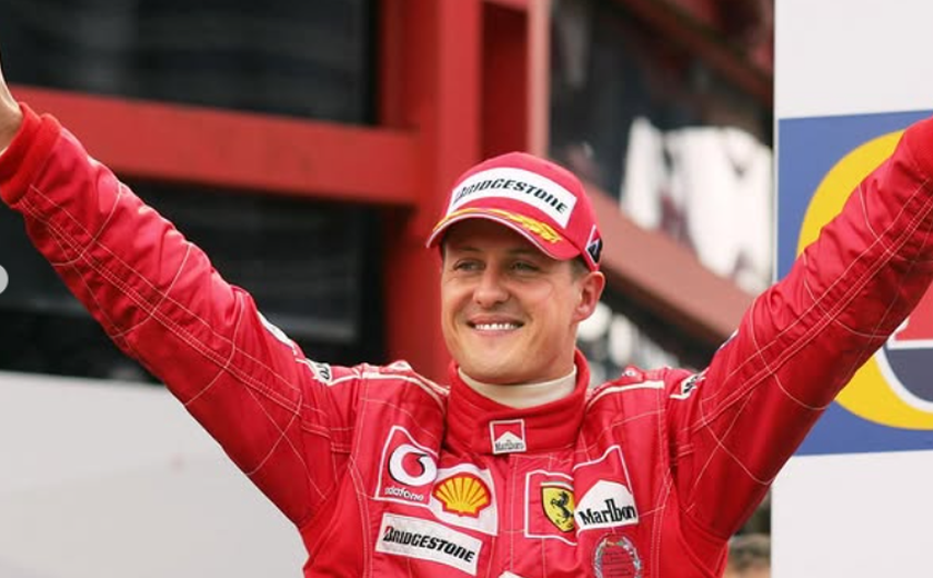 Com ajuda da esposa, Schumacher assina capacete em rara aparição em tributo da F-1