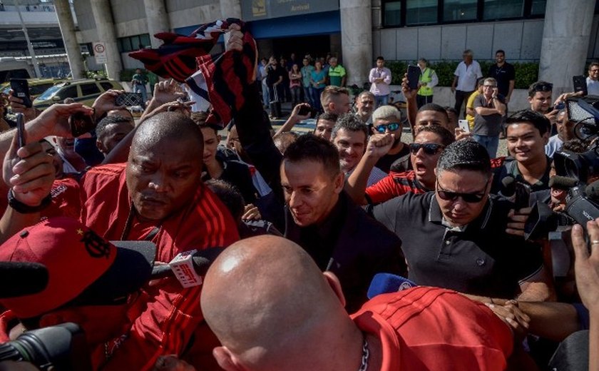 Com samba e pagode, Rafinha é recebido pela torcida do Flamengo na chegada ao Rio