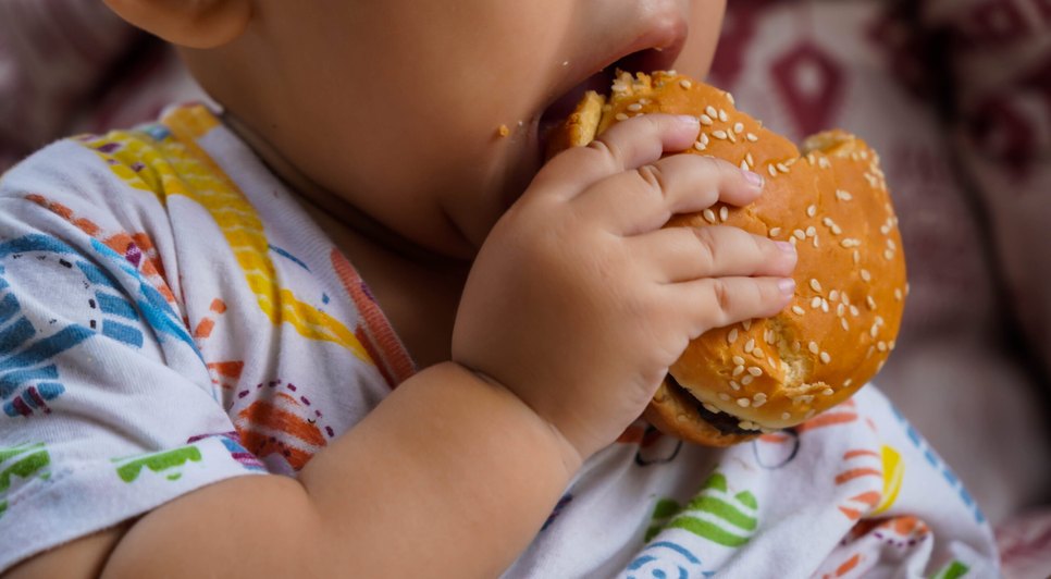 midsection-baby-holding-hamburger-scaled / Foto: Reprodução/Internet