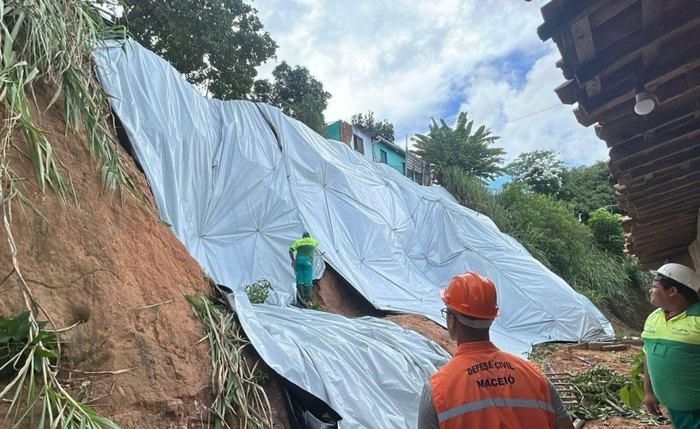 A équipe especializada faz aplicação das lonas nos pontos indicados pela Defesa Civil
