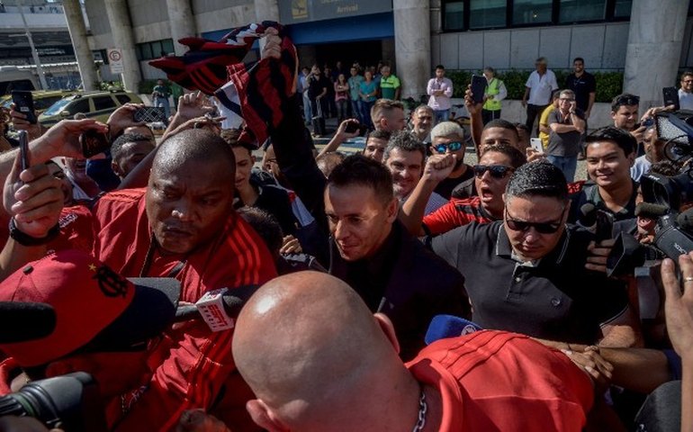 Com samba e pagode, Rafinha é recebido pela torcida do Flamengo na chegada ao Rio
