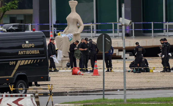 Policiais periciando o corpo de Francisco Wanderley Luiz