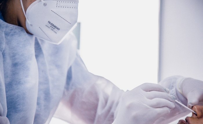 Profissional realiza teste RT-PCR em paciente com sintomas gripais