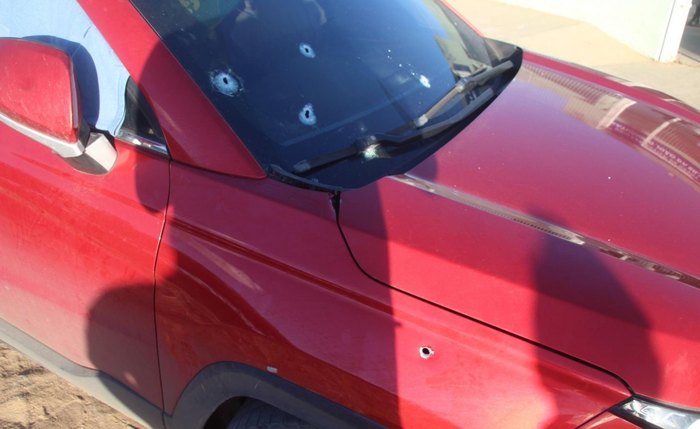 Disparos de arma de fogo atingiram o pára-brisas, a lateral dianteira e a porta do carona