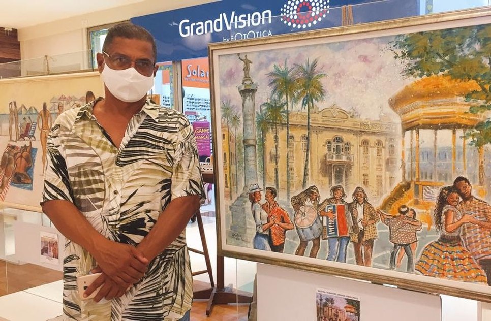 Cartunista Edidelson Silva ao lado de uma de suas obras no Festival Colora / Foto: Foto: Fundação Cultural Cidade de Aracaju (Funcaju)