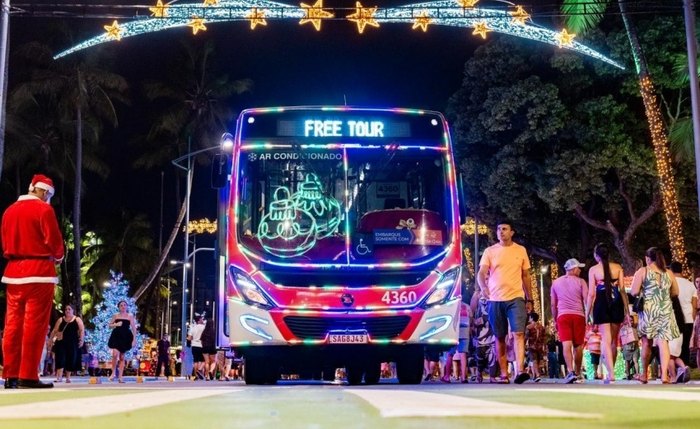Ônibus decorados transportam passageiros para tour natalino na orla marítima