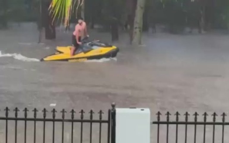 Homem pilota jet ski em rua alagada de Sydney