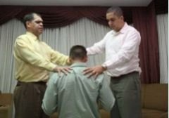 Jovem aceitando a Cristo com pastor da Assembleia