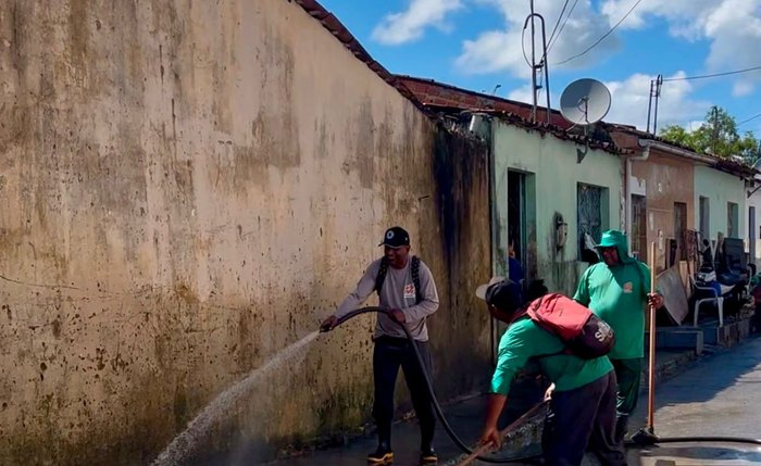 Trabalhadores da prefeitura fazem a limpeza das ruas que foram inundadas pelo Rio São Miguel