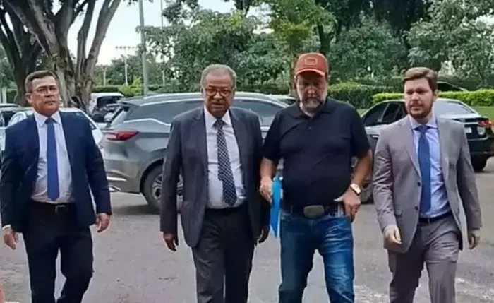 Chicão (de boné) ao lado de advogados ao chegar na Presidência da República