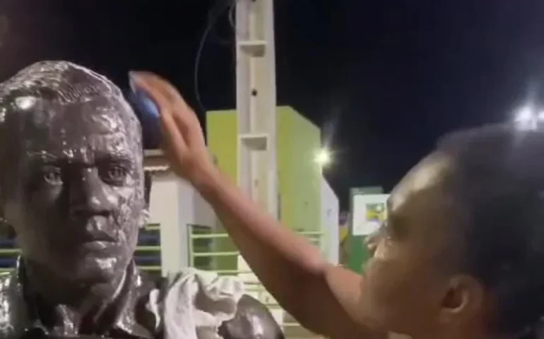 Mulher limpa estátua de Daniel Alves que foi pichada em Juazeiro