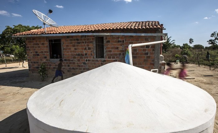 Cisterna em frente a uma casa no semiárido do Nordeste