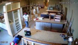 Um dos assaltantes chega no local apontando uma arma para o alto. / Foto: Imagem: Reprodução/TV Atalaia