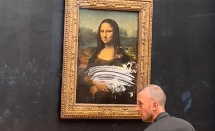 O visitante usava uma peruca e cadeira de rodas, e atirou um bolo na obra de Leonardo Da Vinci O visitante usava uma peruca e cadeira de rodas, e atirou um bolo na obra de Leonardo Da Vinci