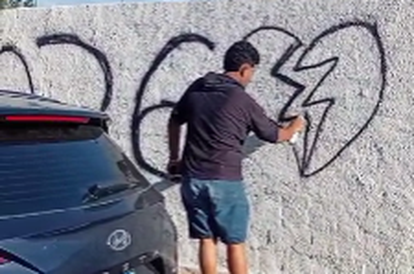 Homem é flagrado pichando muro recém-pintado do Cemitério São Luís, em Maceió