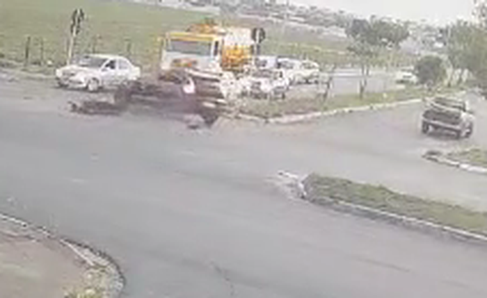 Momento em que motociclista é arremessado e atropelado por carreta após colisão