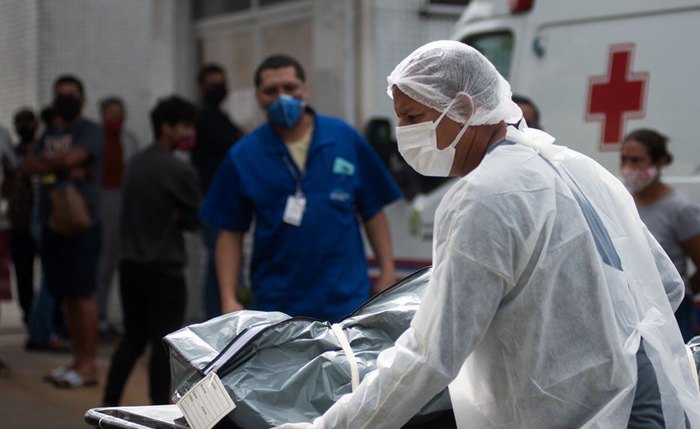 Profissional carrega maca com mais um corpo de paciente em hospital de Manaus