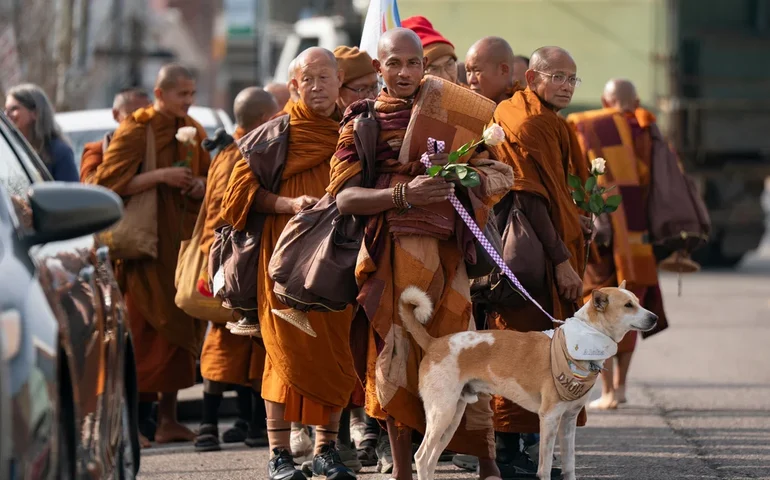 Monges budistas e seu cão cativam americanos enquanto caminham pela paz