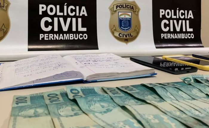 Caderno e quantia de dinheiro encontrada pela polícia Caderno e quantia de dinheiro encontrada pela polícia