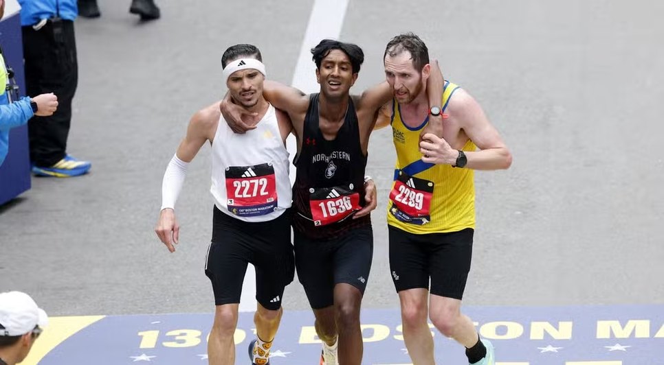 Robson Oliveira (de branco) e Aaron Beggs (de amarelo) ajudaram Ajay Haridasse (de preto) a finalizar a maratona