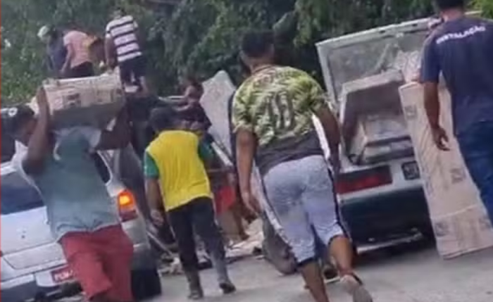 Pessoas saqueiam móveis após caminhão tombar na BR-101, em Flexeiras Pessoas saqueiam móveis após caminhão tombar na BR-101, em Flexeiras