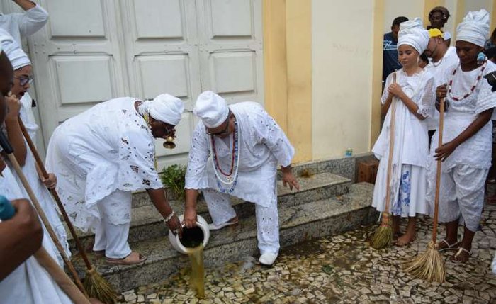 Participantes do evento lavam a calçada da Igreja do Bonfim, em Maceió