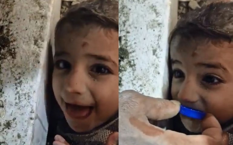 Na Turquia, criança recebe água em tampa de garrafa ainda presa em escombros