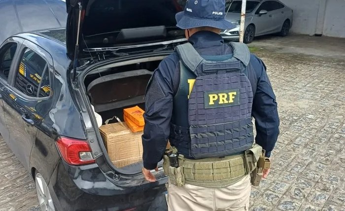 Dentro do automóvel, foram encontradas duas caixas contendo diversos tabletes de maconha prensada