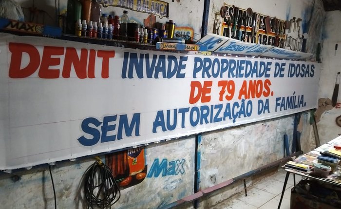 Faixa denuncia invasão da terra cuja proprietária tem 79 anos na BR 316