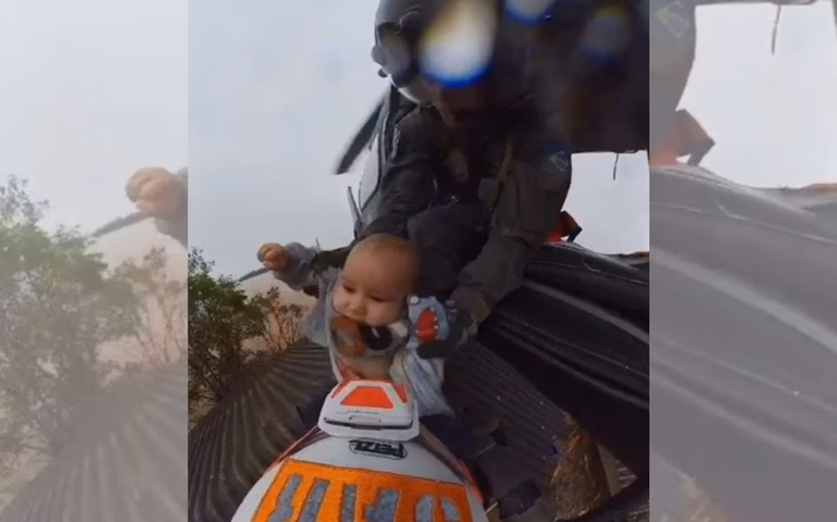 Bebê é transportado em caixa de plástico para passar em ruas alagadas pela enchente na Índia; vídeo