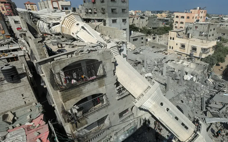 Criança tenta escapar de escola incendiada por bombardeio israelense na Faixa de Gaza