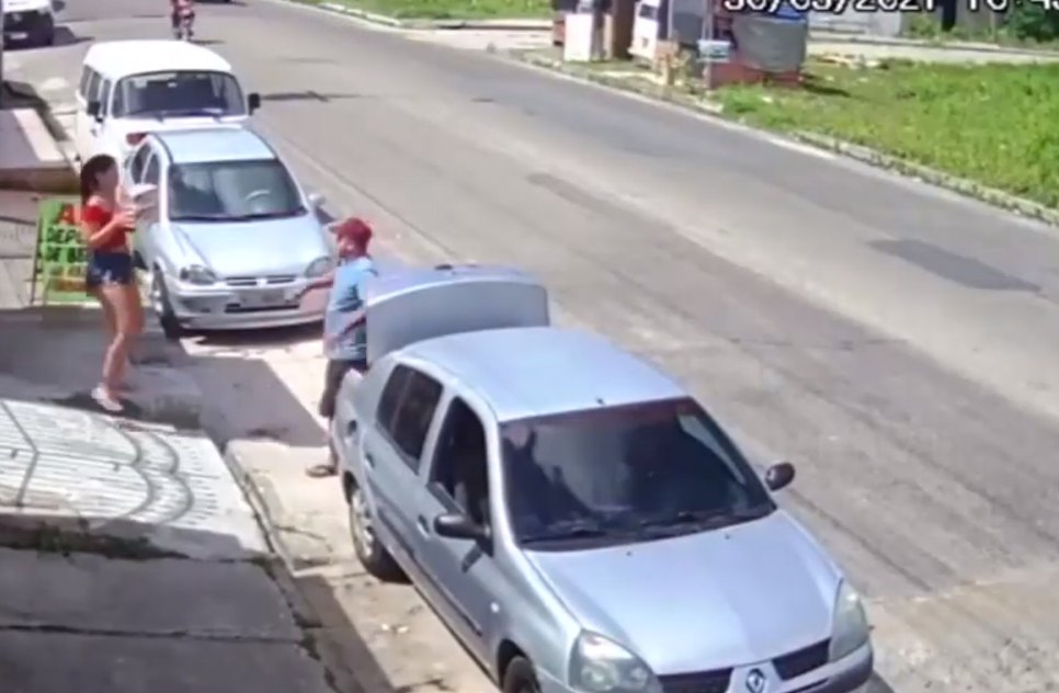Casal envolvido na ação coloca caixas de cerveja no porta-malas de um carro. / Foto: Imagem: Reprodução/TV Atalaia