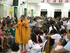 Elúzia, como "Dona Alforja", contando historinha