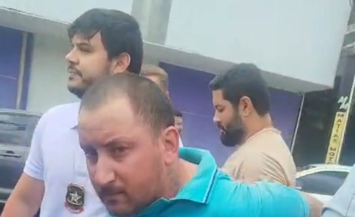 Suspeito, de camisa verde e cujo nome não foi divulgado, ao ser preso por policiais