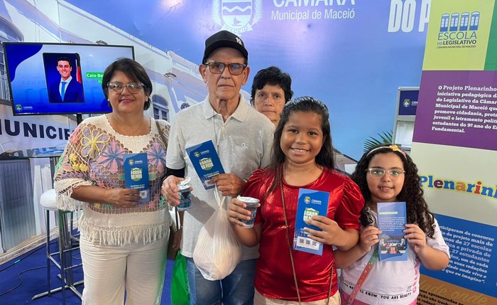 Visitante da Feira dos Municípios posam com folhetos informativos sobre atividades na Câmara de Maceió