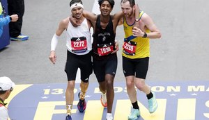 Robson Oliveira (de branco) e Aaron Beggs (de amarelo) ajudaram Ajay Haridasse (de preto) a finalizar a maratona