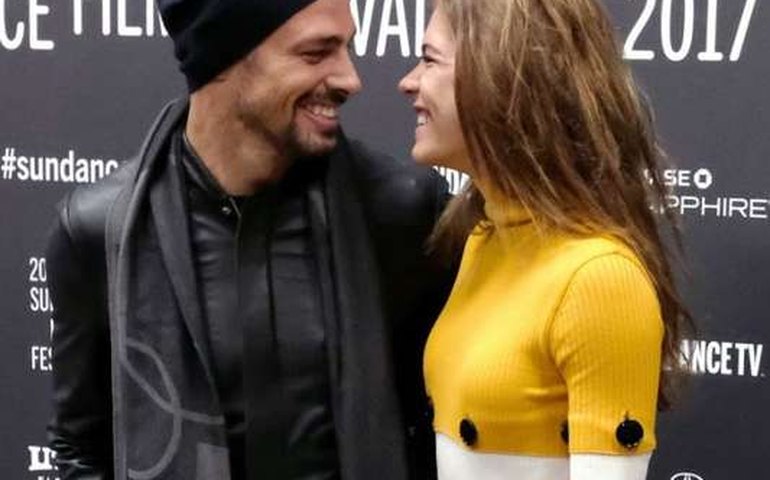 Cauã Reymond troca olhar apaixonado com a namorada em lançamento de filme.