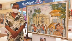 Cartunista Edidelson Silva ao lado de uma de suas obras no Festival Colora / Foto: Foto: Fundação Cultural Cidade de Aracaju (Funcaju)
