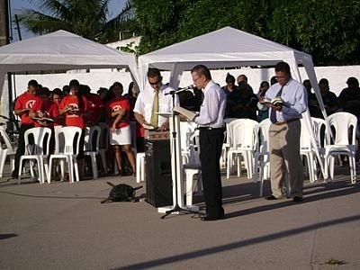 Ao microfone, o pastor Alcir Borges. Ele é observado pelos irmãos numa concentração