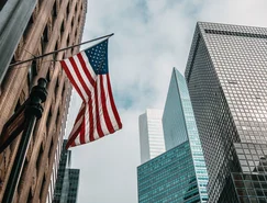 usa-united-states-america-flag-flagpole-near-skyscrapers-cloudy-sky.jpg 