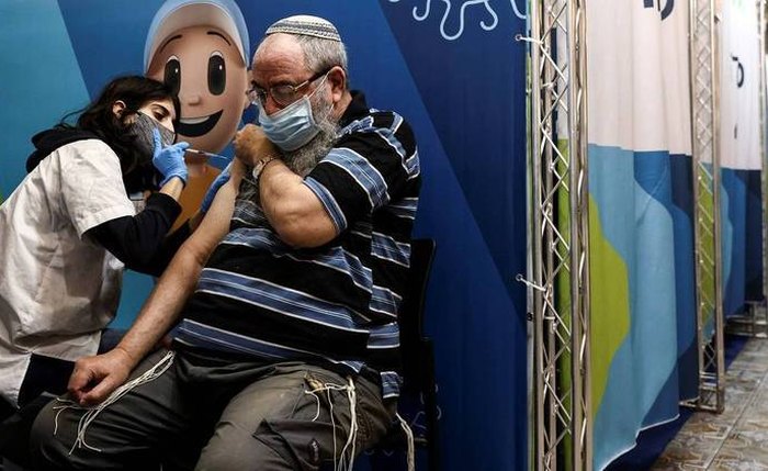 Idoso recebe terceira dose da vacina em Israel Idoso recebe terceira dose da vacina em Israel