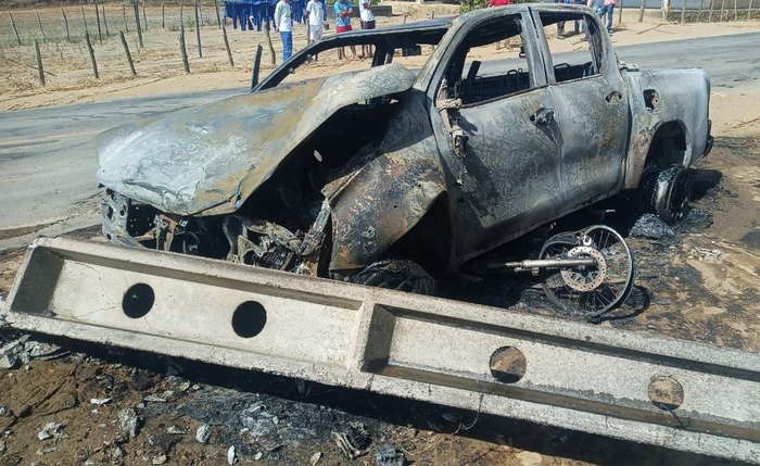 Veículo ficou totalmente destruído pela colisão e pelo incêndio ao se chocar com o poste