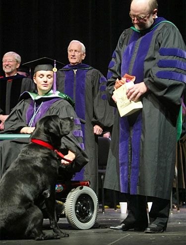 O labrador Skeeter acompanha sua dona, Amy Jones, durante formatura