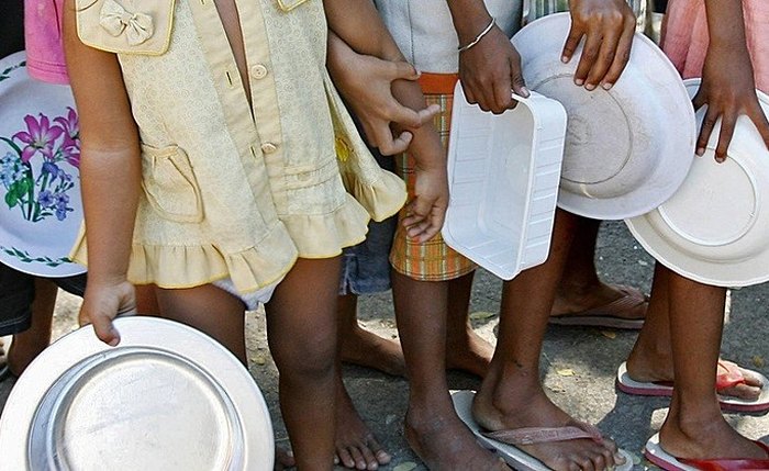 Crianças com prato vazio aguardam distribuição de alimentos Crianças com prato vazio aguardam distribuição de alimentos