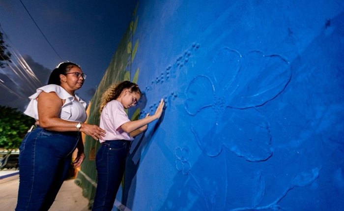 A menina Mika, que é cega, interage com a arte sensorial da nova praça A menina Mika, que é cega, interage com a arte sensorial da nova praça