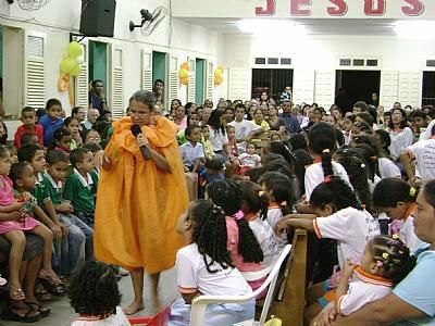 Elúzia, como "Dona Alforja", contando historinha