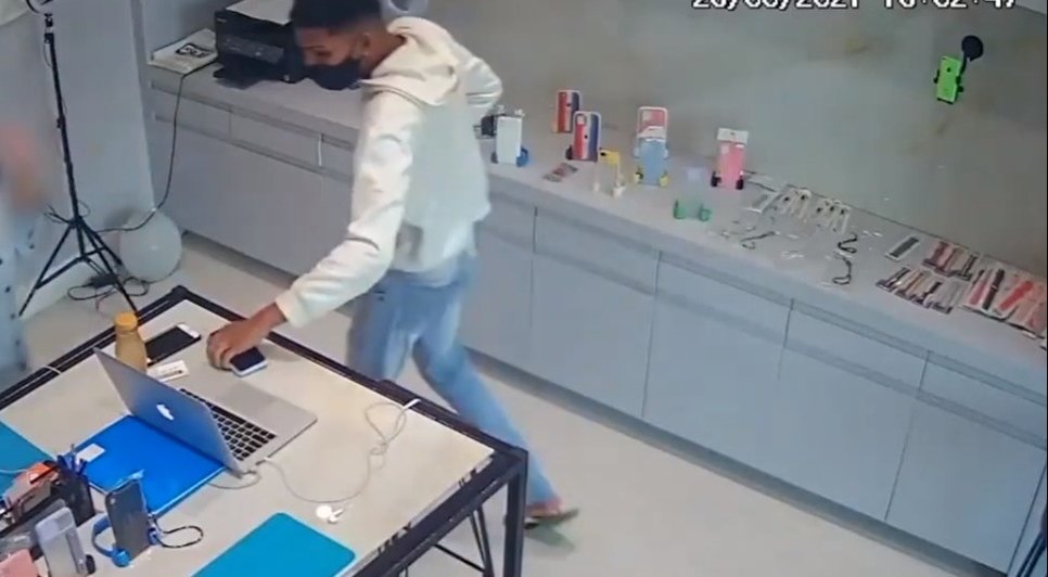 Primeiro dos três suspeitos entra na loja com arma em punho e rende funcionária. / Foto: Imagem: Reprodução/TV Atalaia