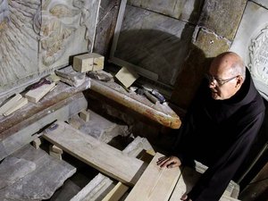 Frei Franciscano observa o local em que Jesus Cristo teria sido sepultado, segundo a tradição cristã. Após a remoção das placas de mármore, foi possível encontrar, intacta, a cama funerária onde acredita-se que o corpo teria sido colocado. (Gali Tibbon/AF / Foto: Everton
