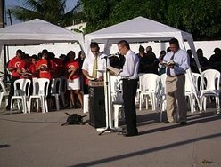 Ao microfone, o pastor Alcir Borges. Ele é observado pelos irmãos numa concentração