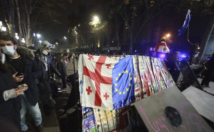 Manifestantes atiram objetos em chamas no prédio do Parlamento após governo adiar entrada na UE